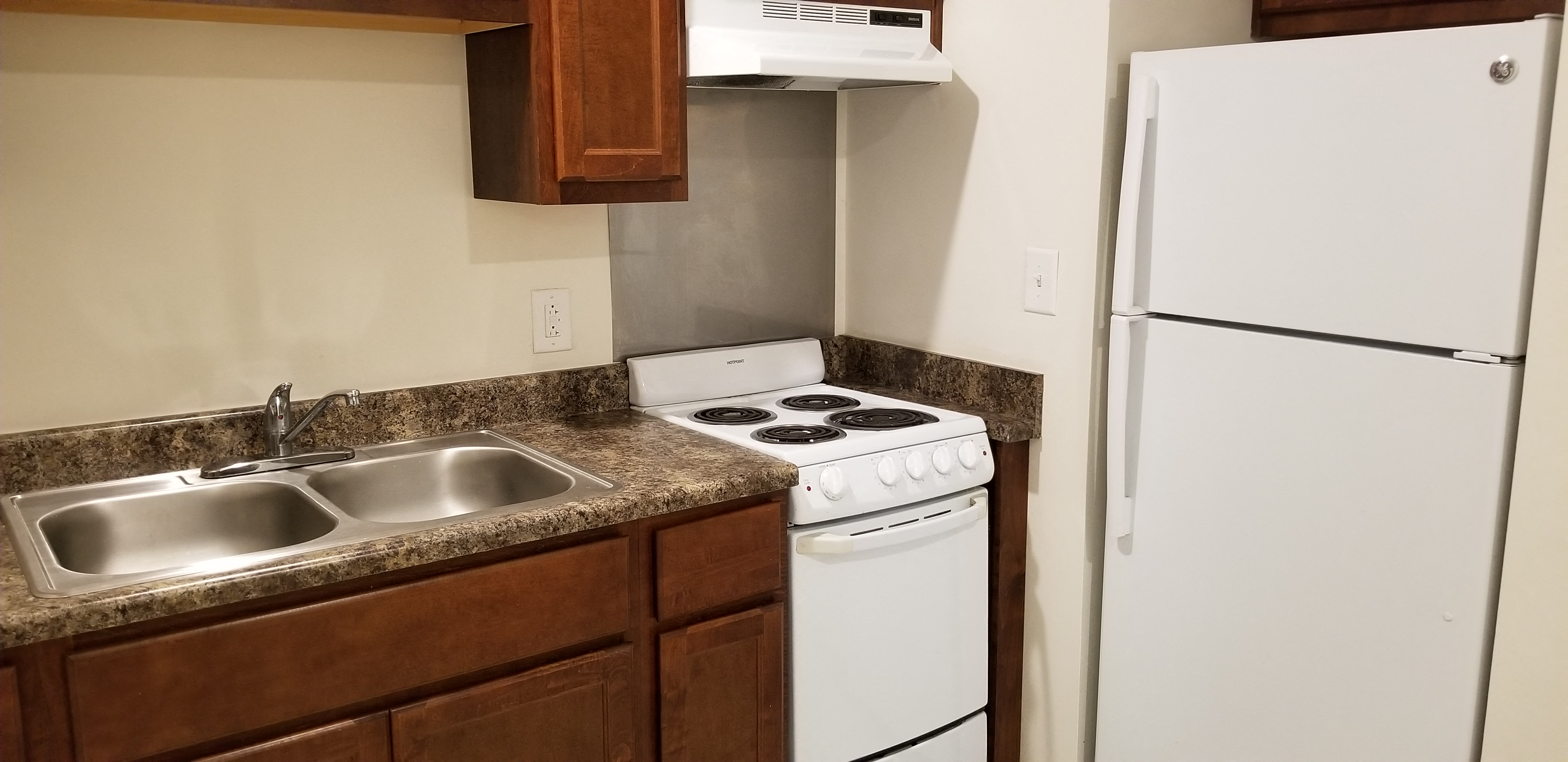 a kitchen with white appliances and a sink and a refrigerator